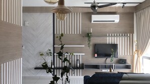 A modern living room with a flat-screen TV, ceiling fan, and decorative plants. - Kenwingston Square Garden by IdealHub (Cyberjaya)