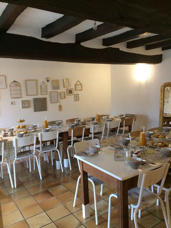 A dining area with multiple tables and chairs, decorated with various framed pictures on the walls. - Le Petit Monty (Saint-Malô-du-Bois)