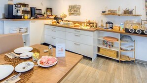 Una cocina moderna con armarios blancos, encimera de madera y varios electrodomésticos.