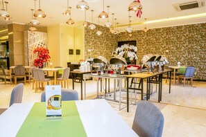 A hotel dining area with tables, chairs, and a buffet setup. - Sunbreeze Hotel Senayan (Jakarta)