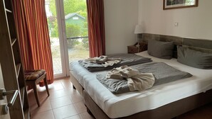 A bedroom with a large bed, a nightstand, a chair, a sliding glass door, and a framed picture on the wall. - Suite Dietmar 11 UR with terrace (SO) - Usedom Suites 11***, beach 100 m (Karlshagen)