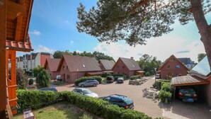 A residential area with multiple brick houses, a parking lot, and a visible balcony. - Suite Dietmar 11 UR with terrace (SO) - Usedom Suites 11***, beach 100 m (Karlshagen)
