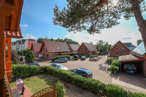 Un quartier résidentiel composé de plusieurs maisons en briques, d’un parking et d’un balcon bien visible.