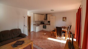 A compact living space with a kitchenette, a dining area, and a sofa. - Suite Dietmar 11 UR with terrace (SO) - Usedom Suites 11***, beach 100 m (Karlshagen)
