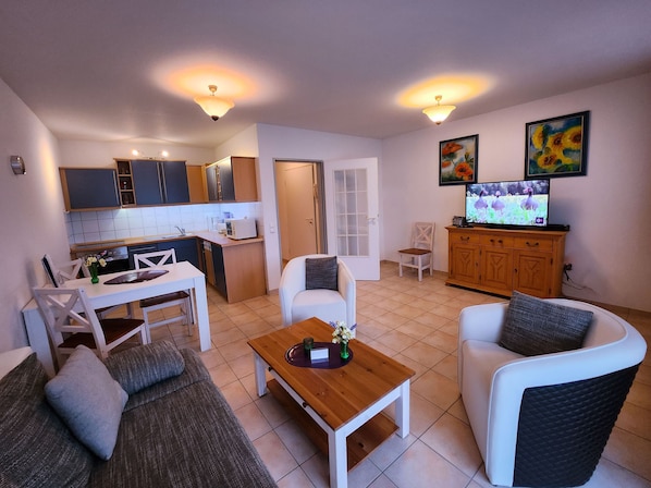 A compact living space with a kitchenette, dining area, and seating arrangement.