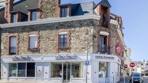 A building with a stone facade, multiple windows, and a sign reading "CAISSE D'EPAIGNE". - Basse Vallée by Interhome (Dinard)