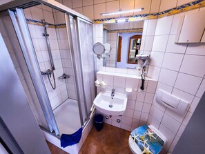 Ein Badezimmer mit Dusche, Waschbecken und Toilette.