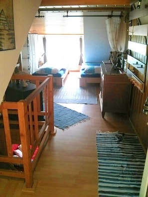 A compact room with a bed, a small desk, and a window with curtains.