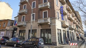 Un hôtel à plusieurs étages doté de balcons, avec une entrée bien visible et un passage pour piétons devant.