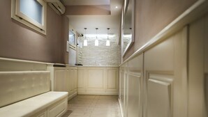 Un couloir étroit avec un banc, un mur en pierre et un escalier offrant une vue sur le ciel.