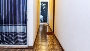 A hallway with wooden flooring and a striped curtain on the left. - Nature Life Guest Inn (Ella)