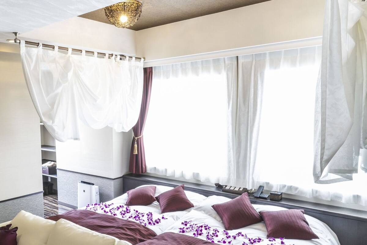 Ett modernt hotellrum med en stor säng, en soffa och ett skrivbord.