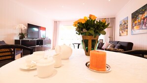A dining area with a table set for tea, a vase with flowers, and a candle. - Beautiful apartment in a dream location near the Festival Hall (Baden Baden)