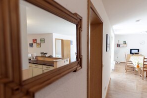 Eine moderne Küche mit Holztresen, einem Herd und einer Spüle. Ein Essbereich mit Tisch und Stühlen ist ebenfalls vorhanden.