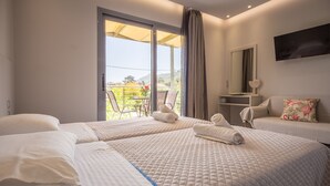 A hotel room with two beds, a balcony, a TV, and a desk with a chair.