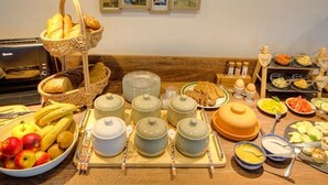 Ein reichhaltiges Frühstücksbuffet mit Brot, Früchten und verschiedenen Speisen.