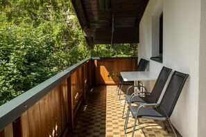 Un patio exterior con cubierta de madera, una mesa y sillas.