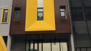 Un edificio con una gran 'I' amarilla en la fachada, un letrero que dice 'Design Hotel' en la parte superior, y una 'V' a la derecha.
