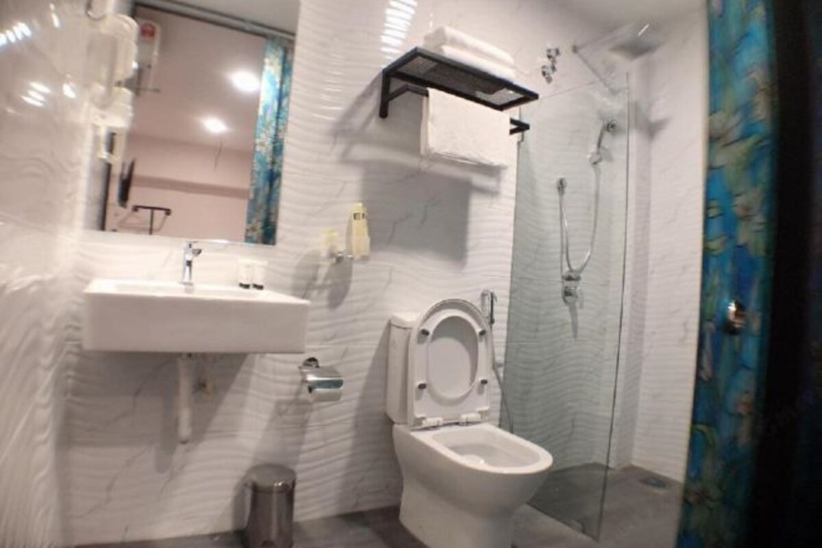 Un baño con lavamanos, inodoro y ducha blancos.