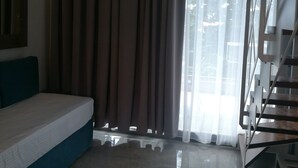 A modern bedroom with a bed, a staircase, and a large window with curtains. - 4-You Family 2 (Polygyros)