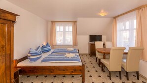 Une chambre d’hôtel avec un lit en bois, un bureau et une télévision.