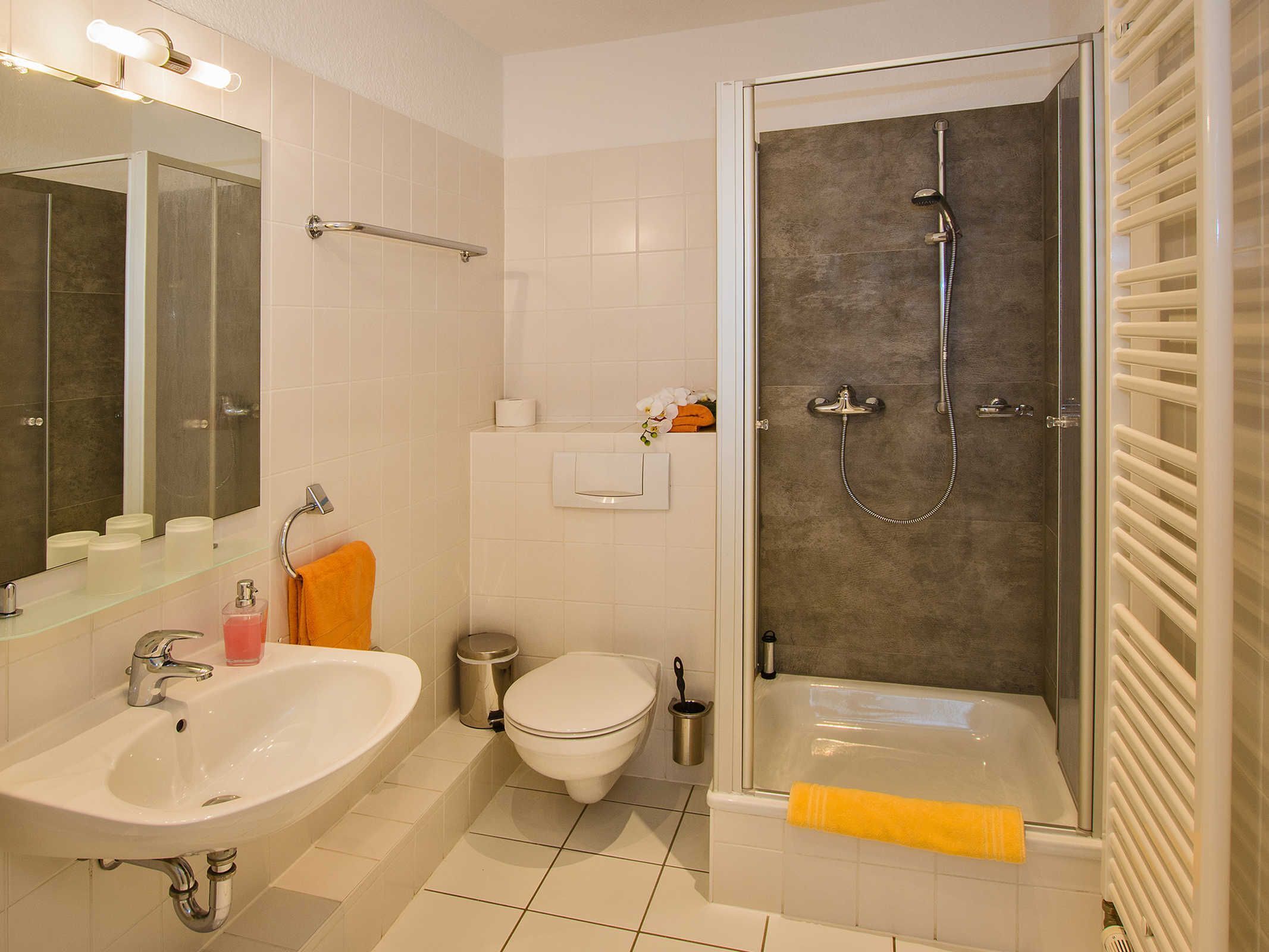A modern bathroom with a sink, toilet, and shower.