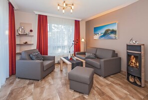 Ein modernes Wohnzimmer mit zwei grauen Sofas, einem kleinen Couchtisch und einem Kamin.