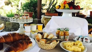 A breakfast buffet with croissants, bread, fruit, and various spreads. - Il Nuraghe Del Lago Coghinas (Oschiri)