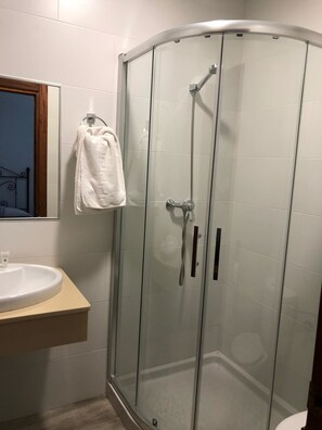 Chuveiro, toalhas de banho, sabonete, shampoo