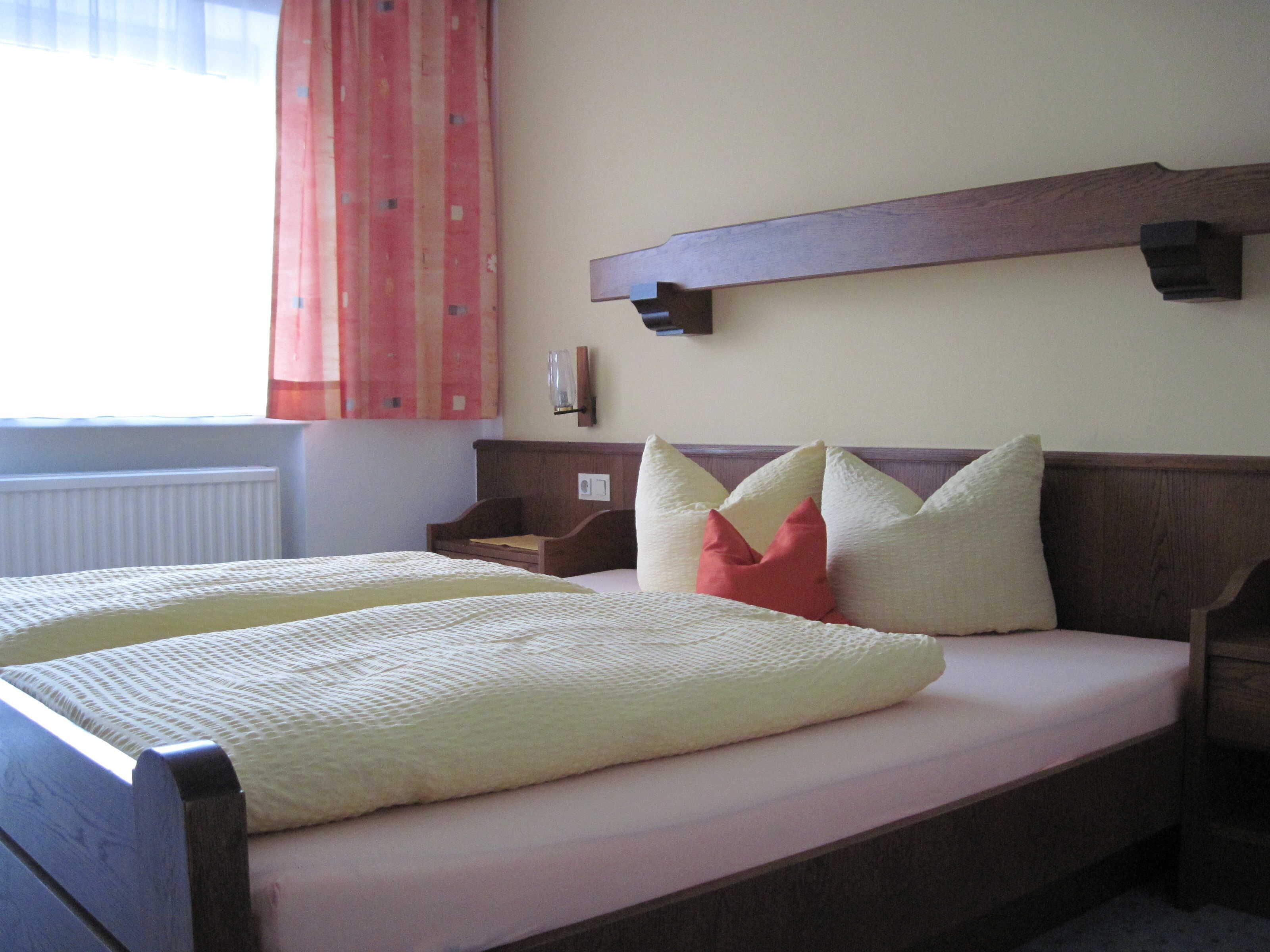 Un lit double avec une tête de lit, une table de chevet et une étagère fixée au mur.