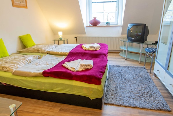 Un dormitorio con dos camas, un televisor y una ventana con vistas.