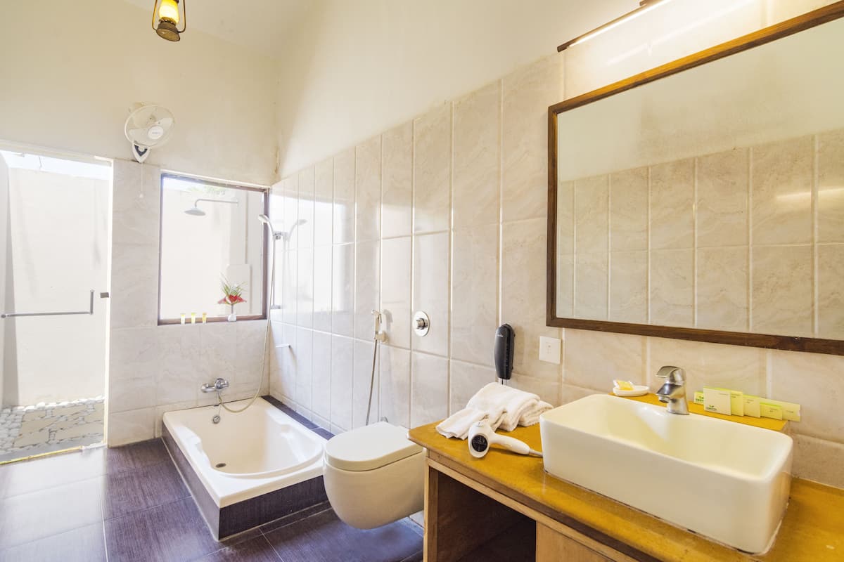 Une salle de bain moderne équipée d’une baignoire, de toilettes et d’un lavabo.