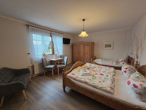 A cozy room with two wooden beds, a small table with chairs, a desk, and a radiator. - 4 - "Up'n Hoff", Germany (Middelhagen)