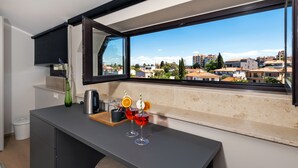 A modern kitchen with a large window, a coffee machine, and two glasses of red drink with orange slices. - Villa Tomo (Rovinj)