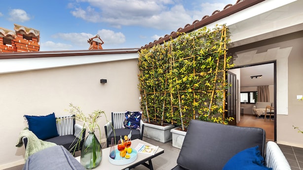 A rooftop terrace with a seating area, a potted plant, and a view into the interior. - Villa Tomo (Rovinj)