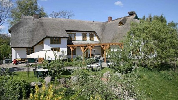 A traditional thatched-roof house with a garden patio area. - 9 - "Up'n Hoff", Germany (Middelhagen)