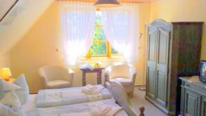 A room with two beds, a chair, a table, and a wardrobe. - 9 - "Up'n Hoff", Germany (Middelhagen)