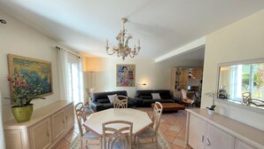 A spacious living area with a dining table, chairs, a sofa, and a chandelier. - Villa Terre de Provence - Pool & Garden Clim prox Golf- Saint-Raphaël (Saint-Raphaël)