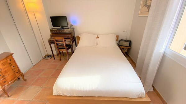 A bedroom with a bed, a desk with a computer, a chair, a radio, and a lamp. - Villa Terre de Provence - Pool & Garden Clim prox Golf- Saint-Raphaël (Saint-Raphaël)
