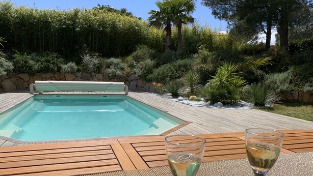 A swimming pool with a wooden deck and two glasses of white wine on a table. - Villa Terre de Provence - Pool & Garden Clim prox Golf- Saint-Raphaël (Saint-Raphaël)