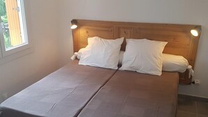 Una cama doble con cabecera de madera y dos lámparas de noche.