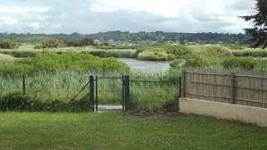 A rural landscape with a gravel path leading to a gated area. - House in the heart of the marshes (Saillé Guérande)