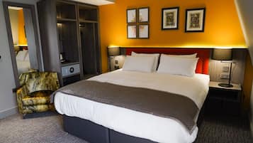 Une chambre d’hôtel avec un grand lit, une armoire, une chaise et des œuvres d’art accrochées au mur.