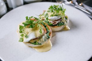 A plate with two poached eggs, spinach, and hollandaise sauce.