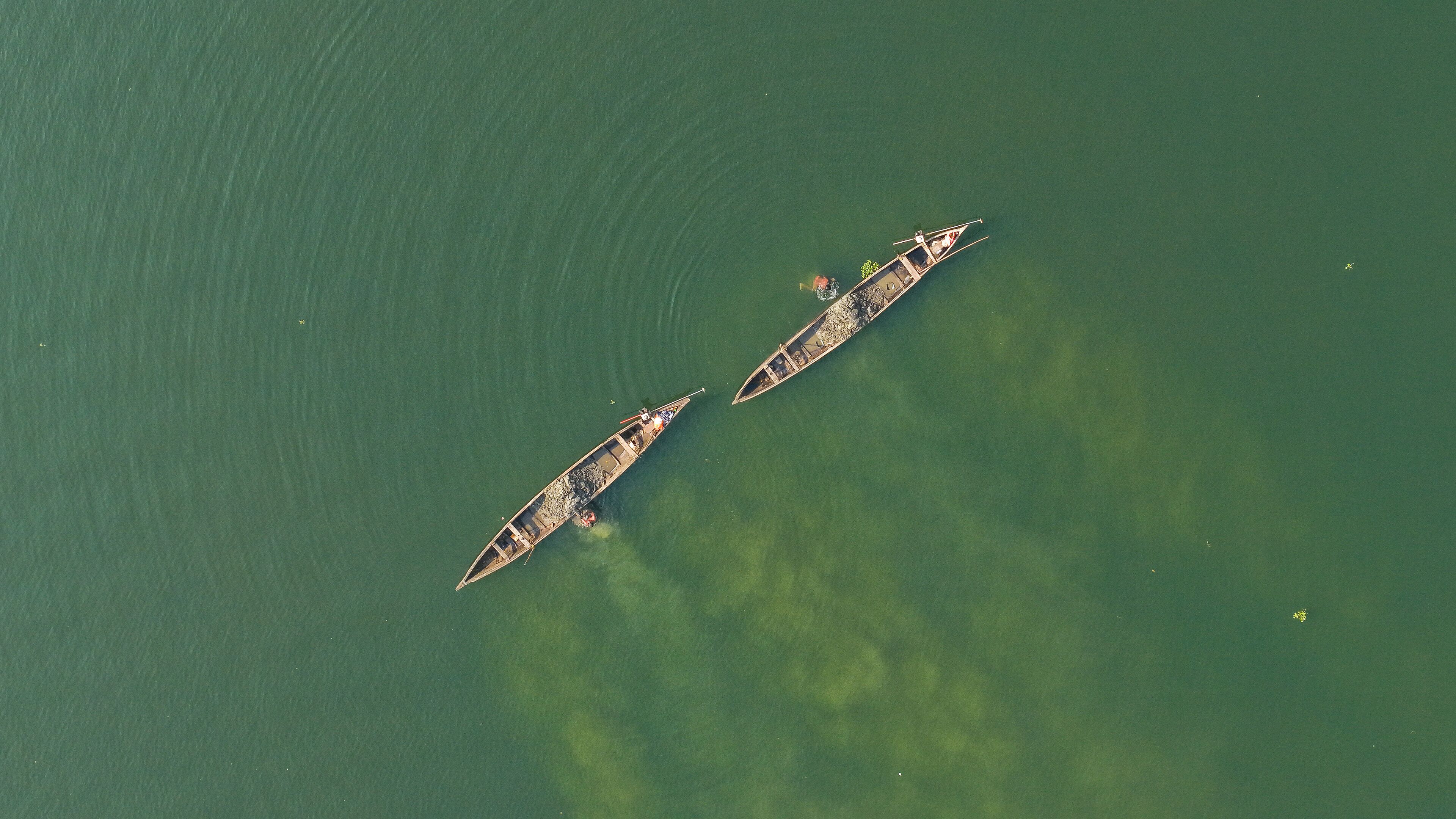 Two boats on a greenish water body.
