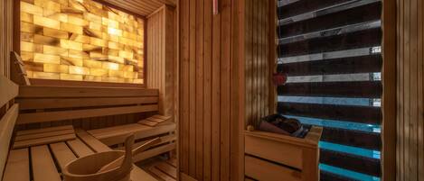 Una sauna de madera con bancos y un cubo de madera.