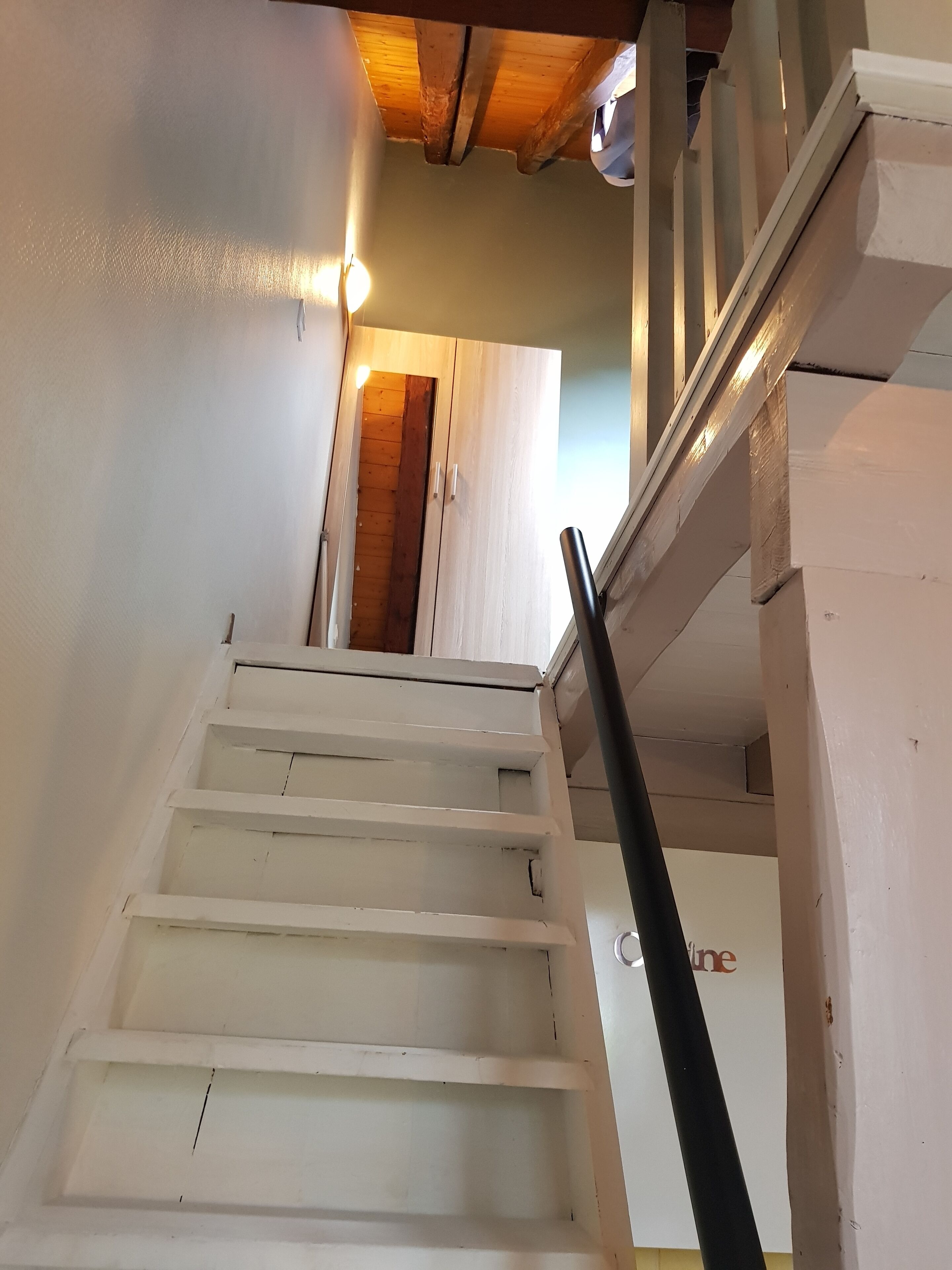 Uma escadaria com degraus brancos que levam a uma porta de madeira.