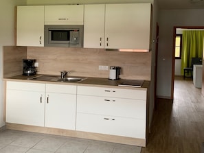 Eine moderne Küche mit integriertem Mikrowellenherd, einer Kaffeemaschine und einem Toaster.