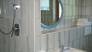 A bathroom with a sink, mirror, and towel rack.
