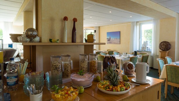 A buffet setup with various food items, a water dispenser, and a coffee station. - An der Pappelwende - five-room apartment type H5 (Karlshagen)